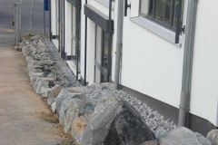 Felsen schützen das Gebäude vor LKW